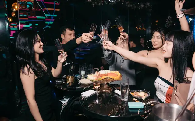 Group toasting with champagne flutes at a club table