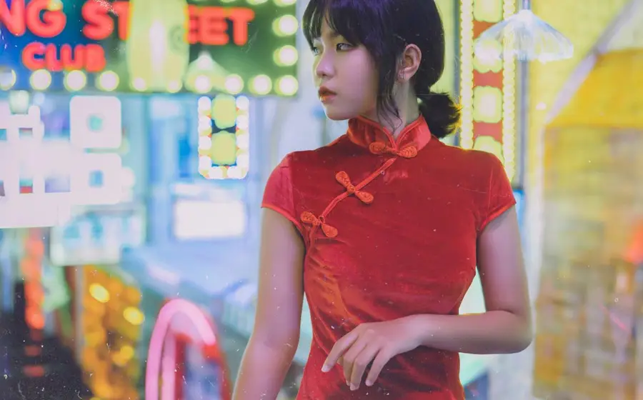 Woman in a red qipao under neon signs